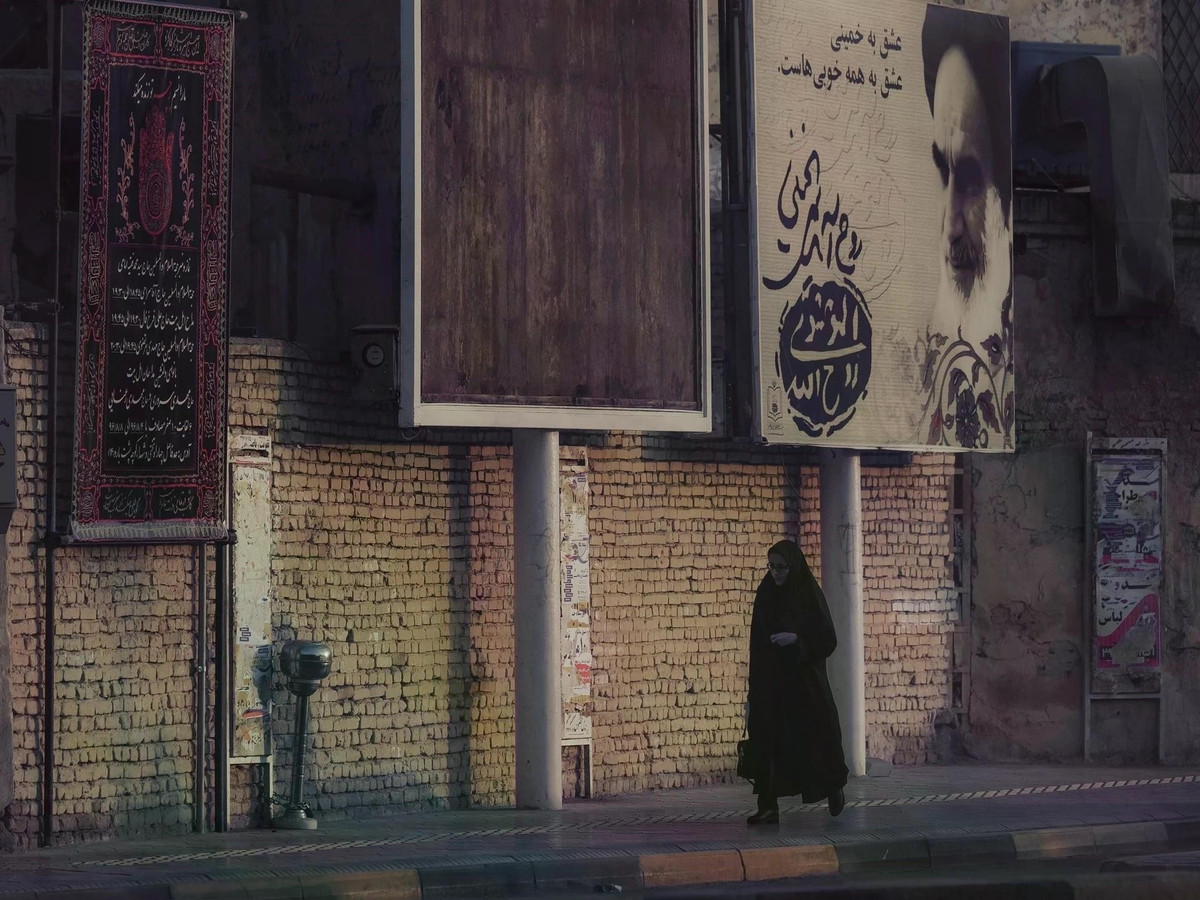 Biển hiệu có chân dung cố lãnh tụ tối cao Iran Ayatollah Ali Khamenei trên đường phố. Phụ nữ ở Iran thường mặc áo choàng đen (chador) phủ từ vai đến chân và trùm khăn hijab để che tóc khi ra đường. Nhưng không phải tất cả phụ nữ Iran đều mặc chador, một số người vẫn chọn trang phục mới mẻ và trùm khăn màu sắc.