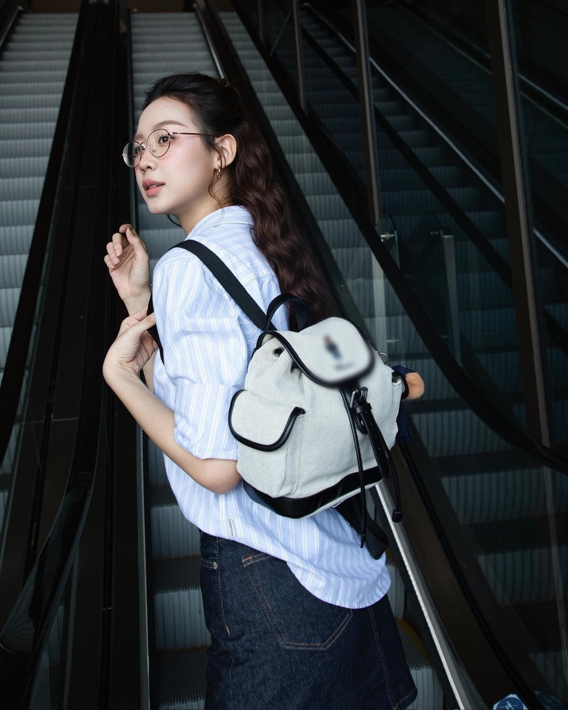 Phụ kiện kính gọng mảnh và túi xách mini tông trắng, vừa tạo điểm nhấn tinh tế, vừa giữ sự hài hòa cho trang phục.