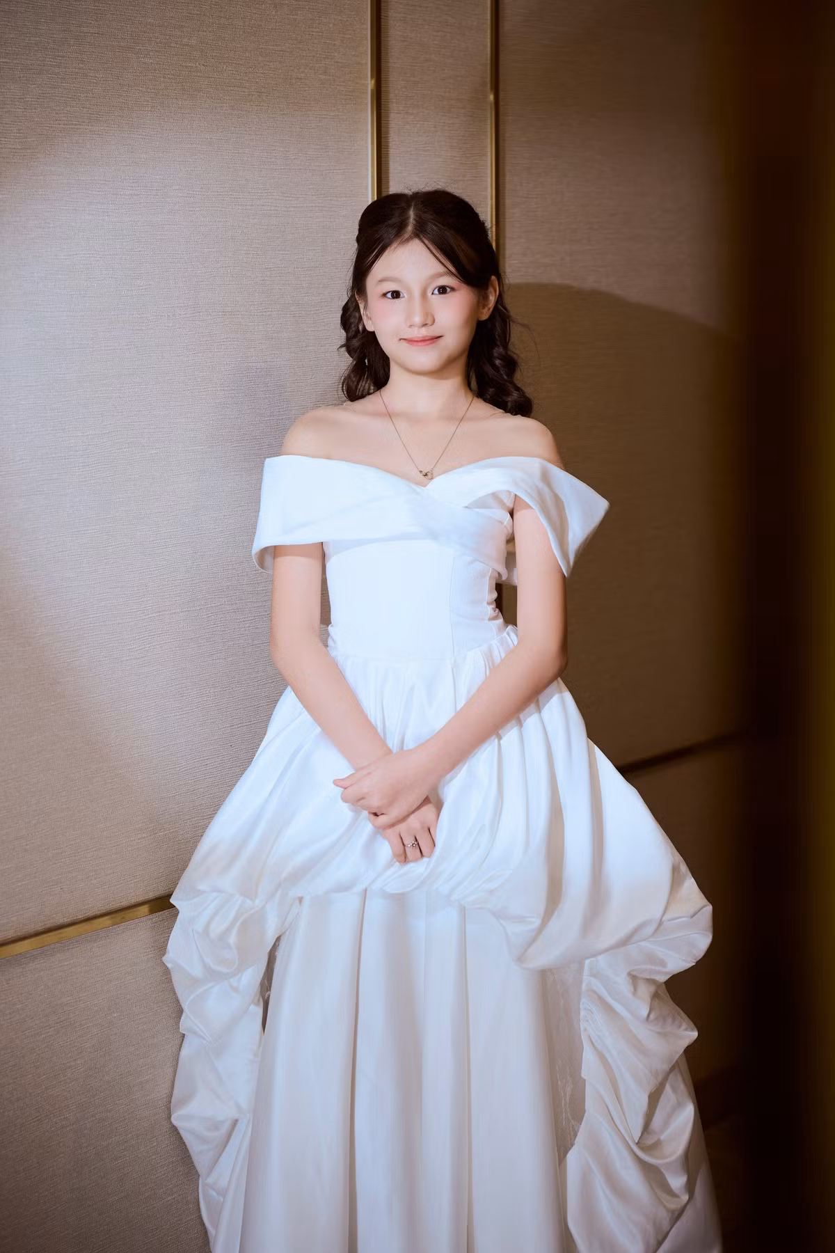 Ailani diện váy trắng cùng tông màu với mẹ, làm tóc xoăn điệu đà.