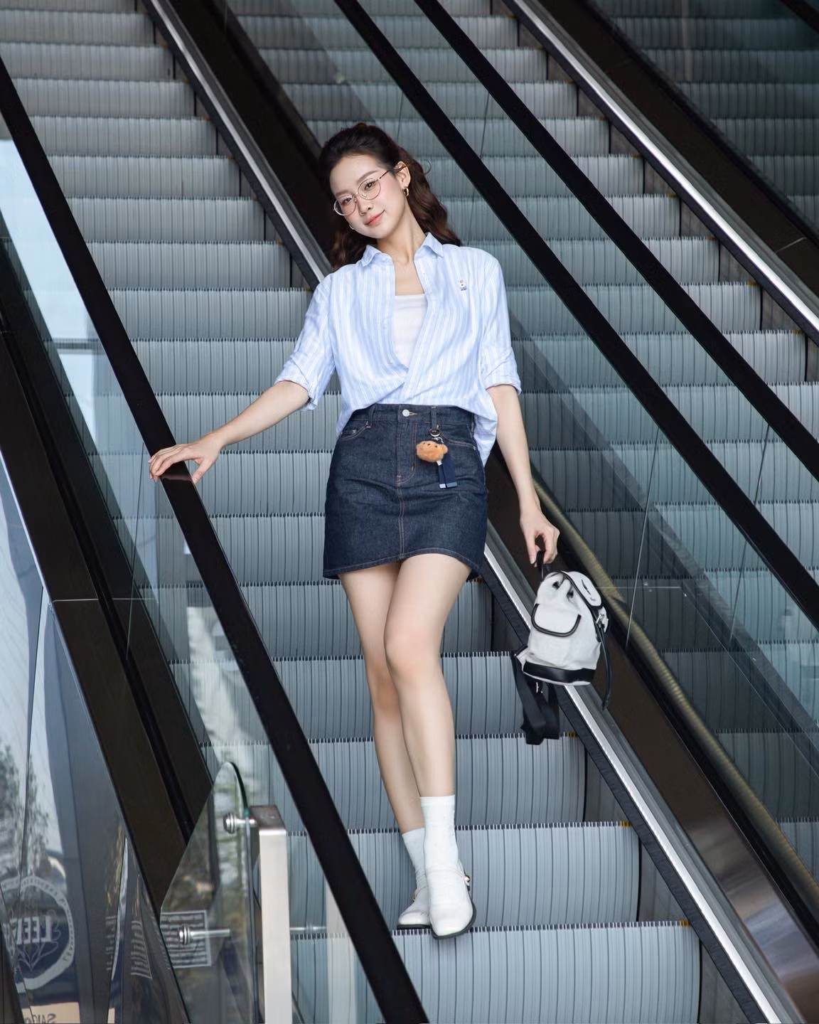 Xuống phố, người đẹp lựa chọn áo sơ mi sọc xanh nhạt dáng rộng, cài hờ cổ áo, mang lại cảm giác thoải mái, tự nhiên.