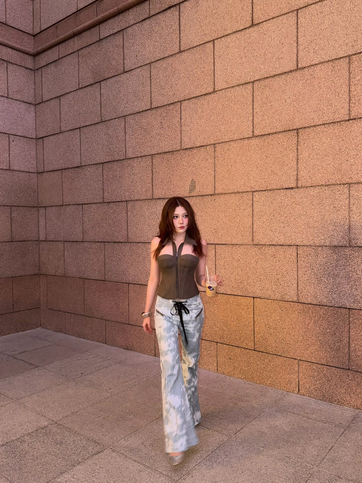 Uyển Ân diện áo corset cúp ngực, quần jeans họa tiết loang ống rộng khi xuống phố mới đây.