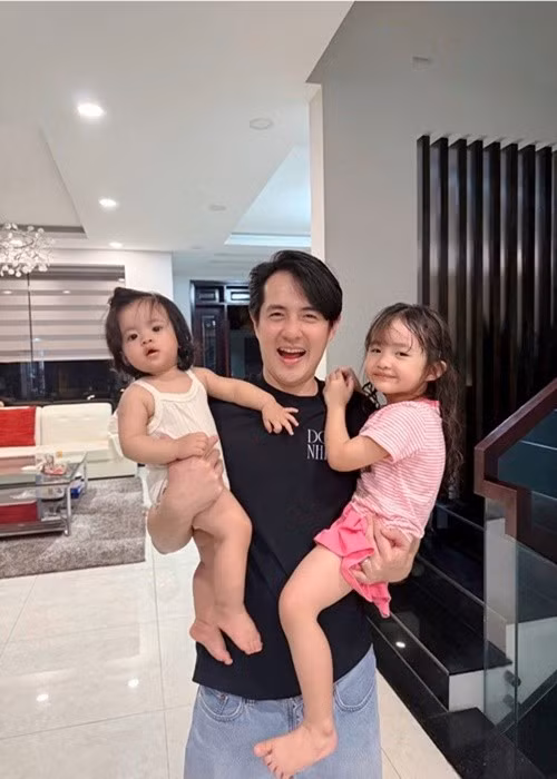 Trở về nhà sau một ngày bận rộn, Ông Cao Thắng được vợ con chào đón. "Đi làm ngày nào về cũng được 3 quý cô đón từ cửa. 1 cô tay trái, 1 cô tay phải, cô còn lại trên ngực trái đang chụp ảnh", Ông Cao Thắng viết trên trang cá nhân. Ảnh: FB Đông Nhi.