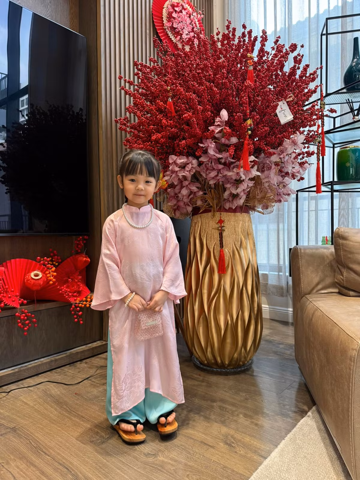 Bé Suchin diện áo dài truyền thống gam hồng pastel dịu nhẹ, chất liệu mềm mại, vừa vặn với dáng người, kết hợp quần xanh ngọc tạo cảm giác hài hòa, tươi tắn. Ảnh: Instagram Suchin - Sutin.