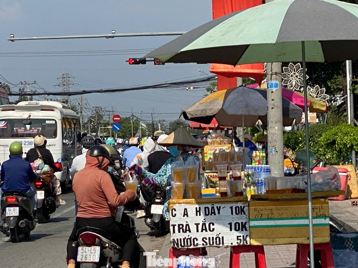 Dưới cái nắng oi bức, người đi đường dừng lại ven quốc lộ mua nước giải khát để tiếp sức tiếp tục hành trình.