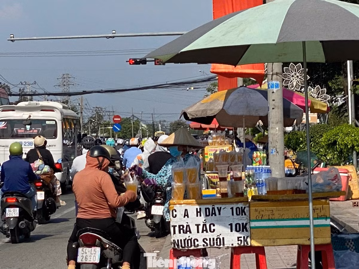 Dưới cái nắng oi bức, người đi đường dừng lại ven quốc lộ mua nước giải khát để tiếp sức tiếp tục hành trình.