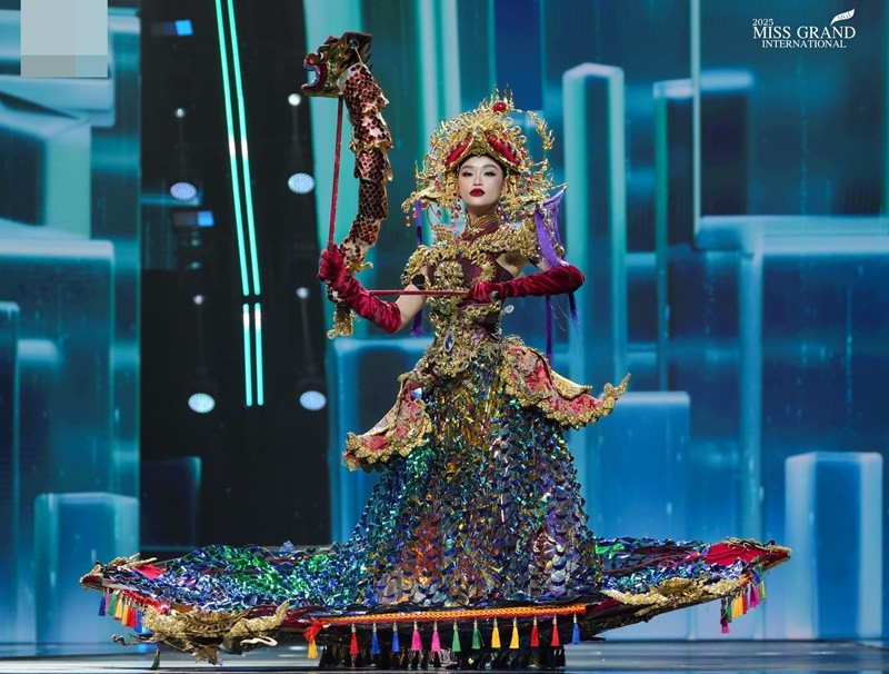 Trước đó, trong phần thi trình diễn trang phục dân tộc thuộc khuôn khổ cuộc thi Miss Grand International 2025, Hoa hậu Yến Nhi tự hào quảng bá nghệ thuật múa rối nước dân gian Việt Nam đến với bạn bè quốc tế thông qua bộ trang phục Thăng Long Hội. Ảnh: Miss Grand International.