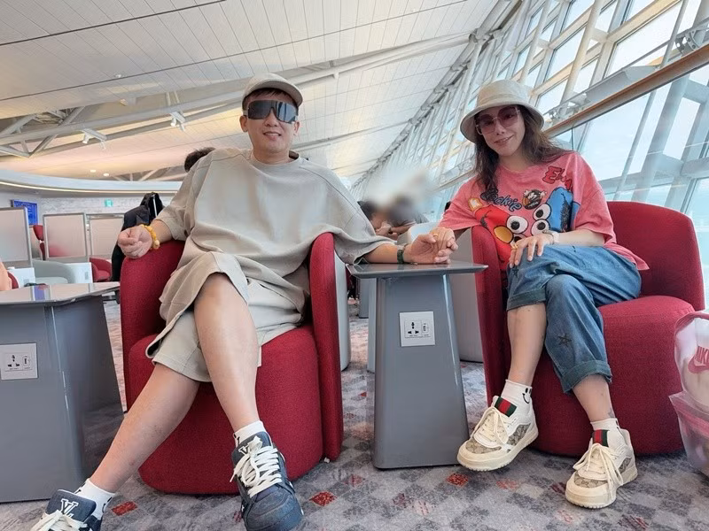 Cặp đôi nắm tay nhau khi chờ chuyến bay, giữ thói quen đồng hành trong cả công việc lẫn cuộc sống. Ảnh: FB Công Thành.