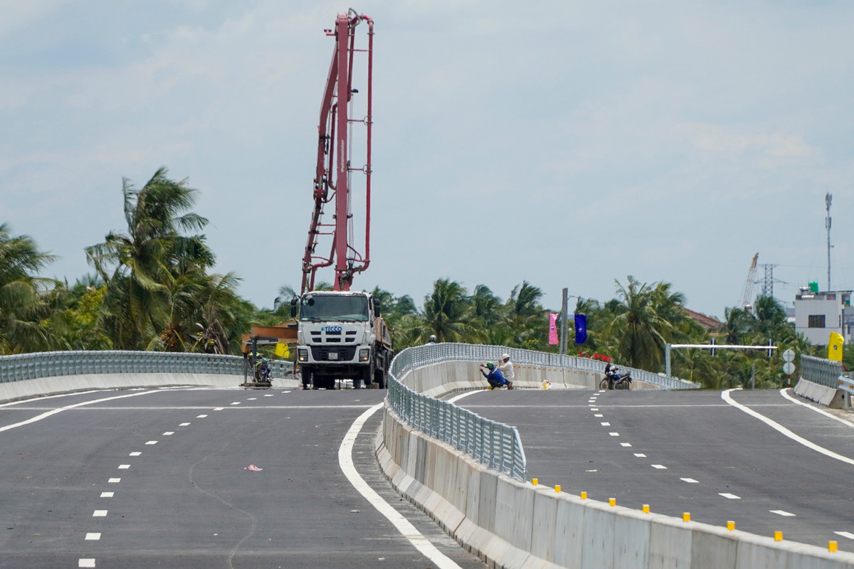 Các hạng mục phụ trợ như lắp phản quang dải phân cách, kẻ vạch trên mặt cầu, lang cang đang được các công nhân gấp rút hoàn thiện.