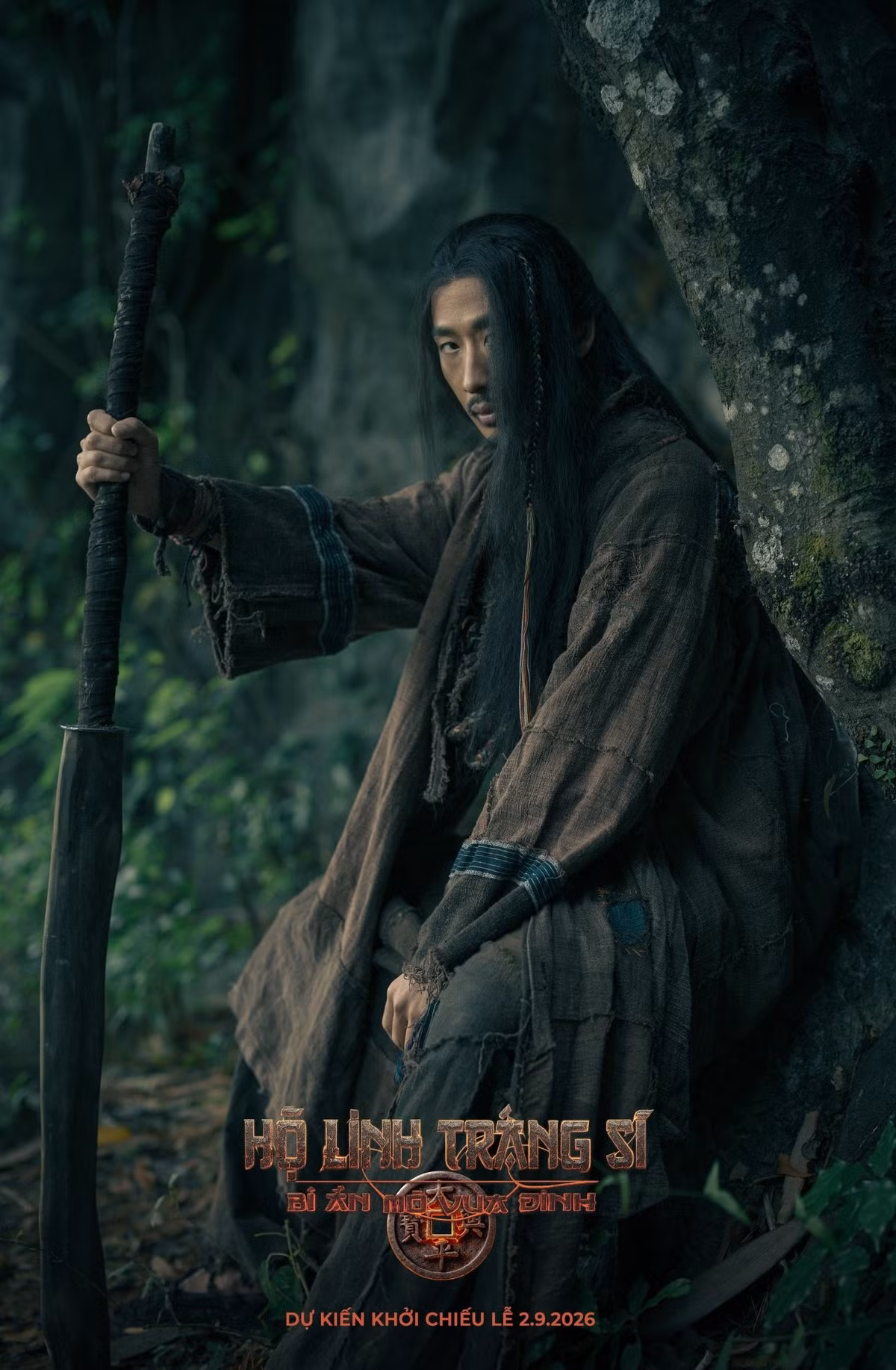 Ở dự án Hộ linh tráng sĩ: Bí ẩn mộ Vua Đinh, Tuấn Trần đảm nhận vai Nguyên Phong – một tráng sĩ áo vải xuất thân thợ săn, được Thầy Mo người Mường (NSND Tự Long) nuôi dạy từ nhỏ. Nhân vật chọn giấu đi tài năng để sống ngoài khuôn khổ, nhưng khi vận mệnh dân tộc xoay chuyển, anh buộc phải bước ra ánh sáng, được lòng trung nghĩa thôi thúc. Ảnh: FB Tuấn Trần.