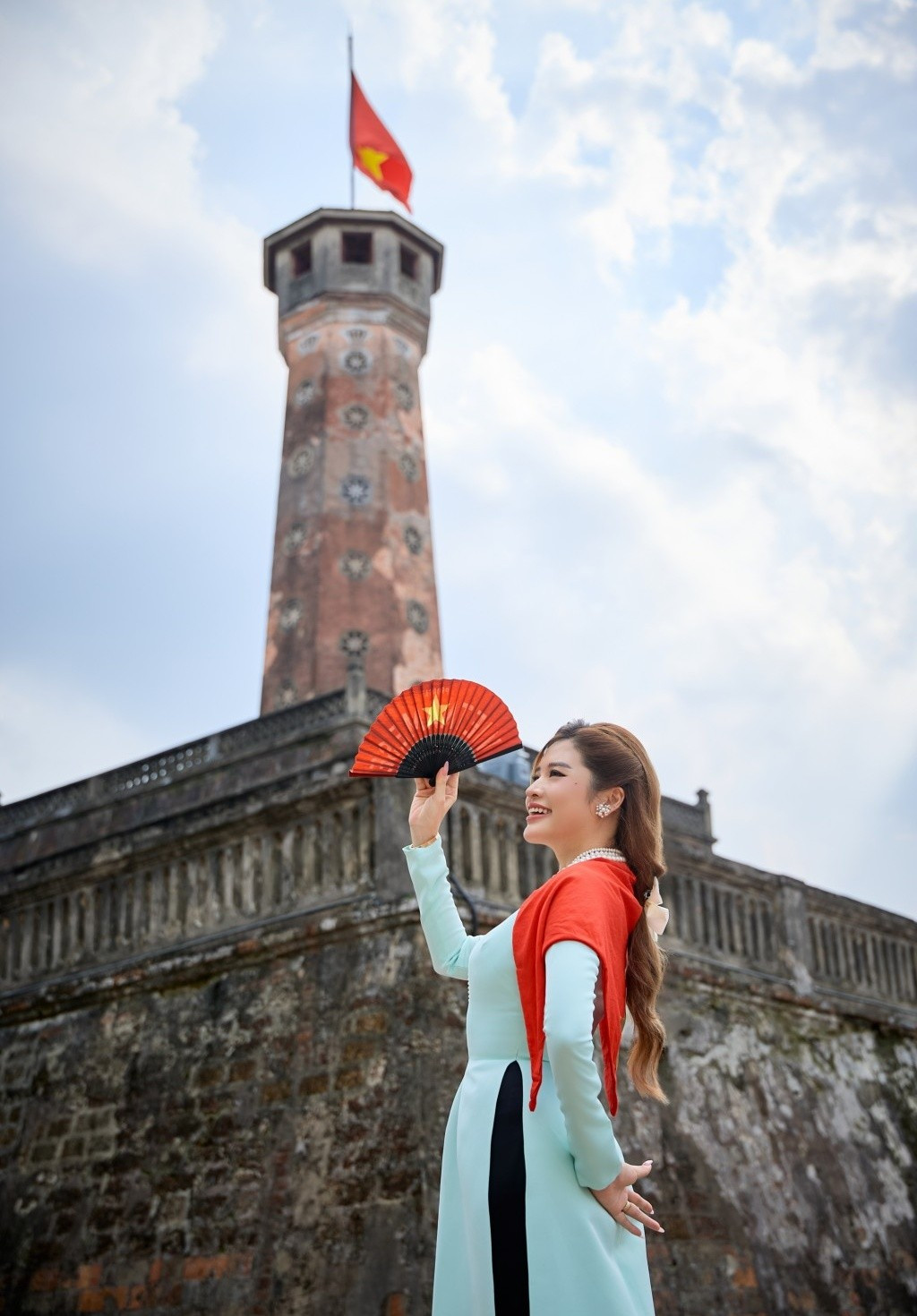 Phan Hoàng Thu thực hiện bộ ảnh áo dài ở những góc phố Hà Nội rực rỡ cờ hoa. Ảnh: Tuổi Trẻ Thủ Đô.