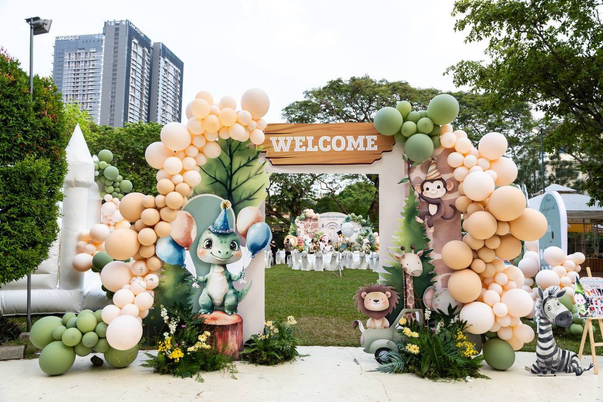 Các hình ảnh hoạt hình động vật (khủng long, sư tử, khỉ, ngựa vằn) được thiết kế sinh động, thân thiện với trẻ nhỏ. Cổng chào được dựng hoành tráng với tông màu chủ đạo là cam đào và xanh.