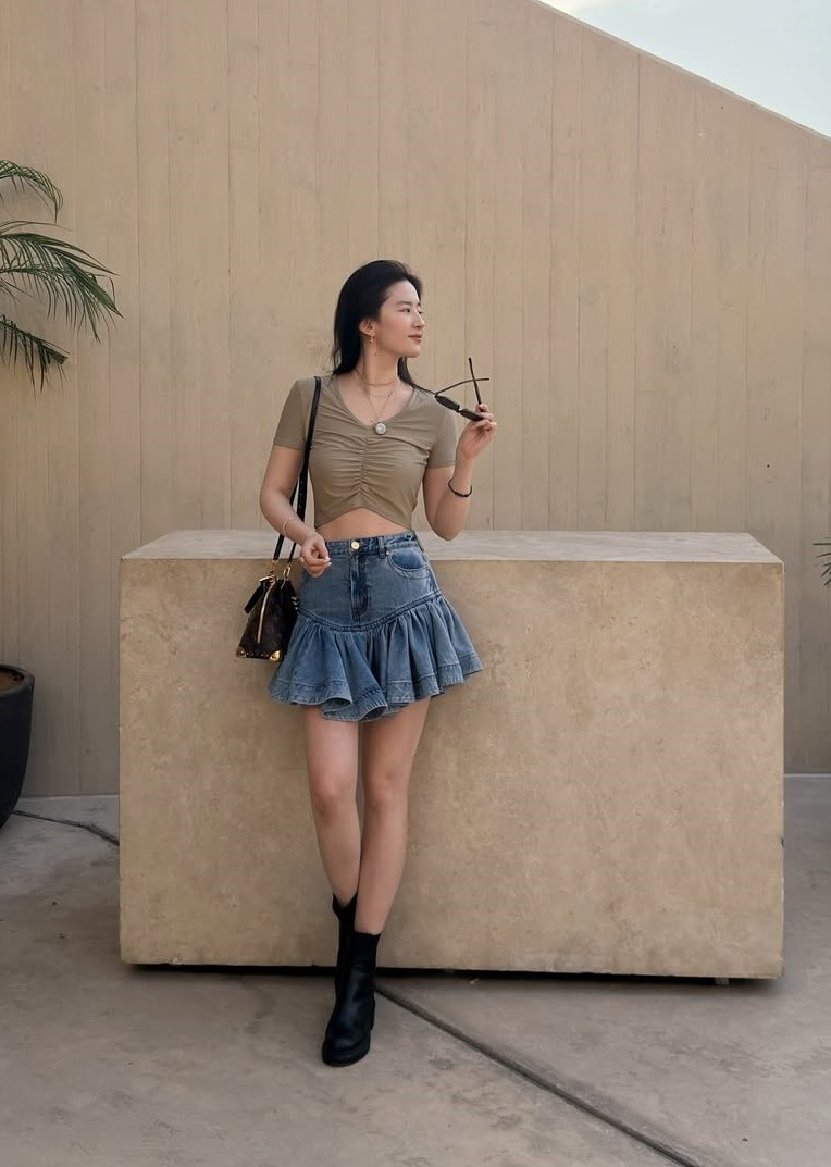 Trong chuyến công tác nước ngoài mới đây, Lưu Diệc Phi mặc trẻ trung, năng động khi xuống phố. Nữ diễn viên diện áo croptop kết hợp chân váy denim xếp ly, đi boots đen cổ ngắn.