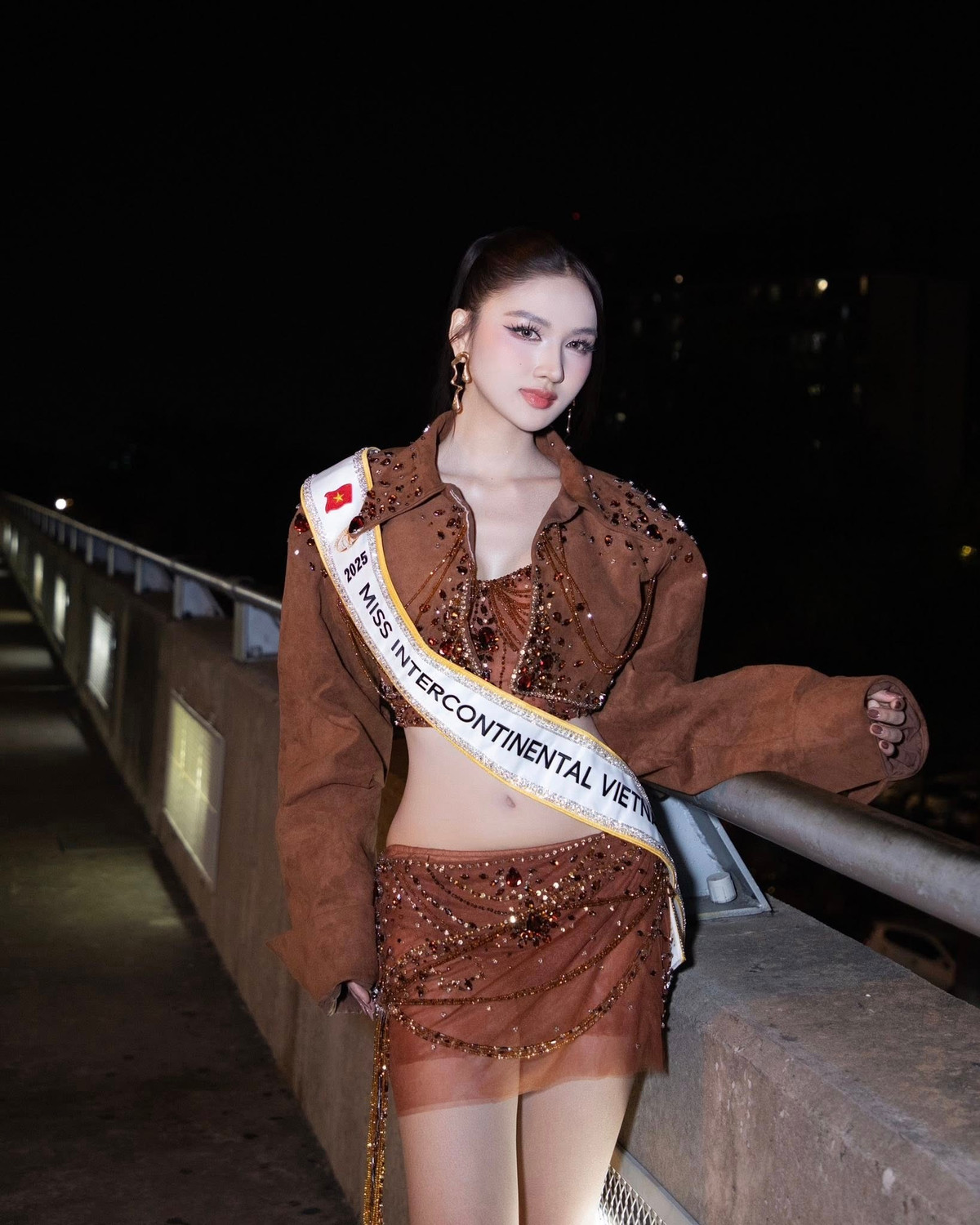 Á hậu Thu Ngân vừa khởi hành sang Ai Cập, bắt đầu hành trình tham gia cuộc thi nhan sắc quốc tế Miss Intercontinental - Hoa hậu Liên lục địa. Tại sân bay, cô diện bộ trang phục hai mảnh tông nâu ánh đồng. Thiết kế ôm sát tôn lên vòng hai con kiến, đôi chân dài thon gọn.
