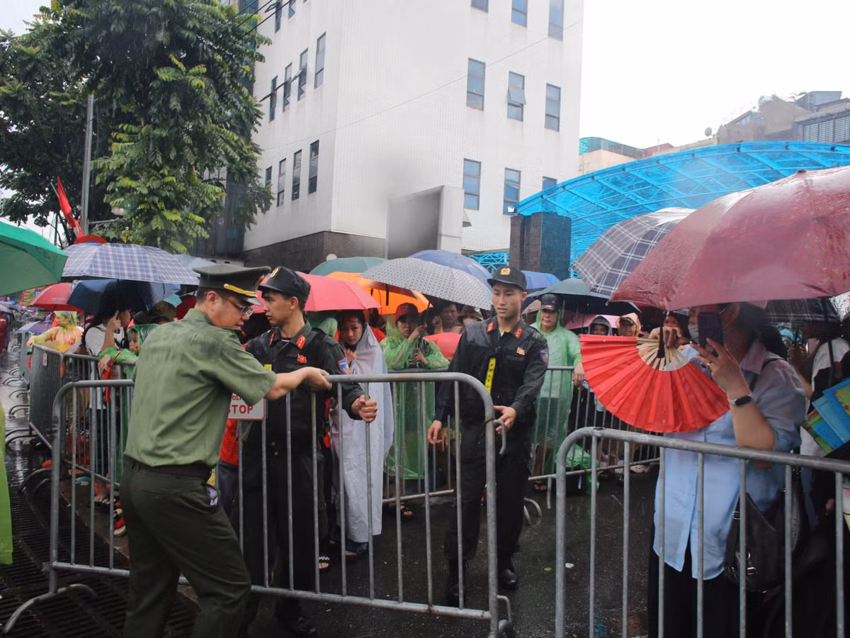 Bất chấp cơn mưa chiều ngày 1/9, trên đường Kim Mã, nhiều người vẫn che ô, mặc áo mưa chờ đợi xem diễu binh A80, dù sự kiện sáng 2/9 mới diễn ra.