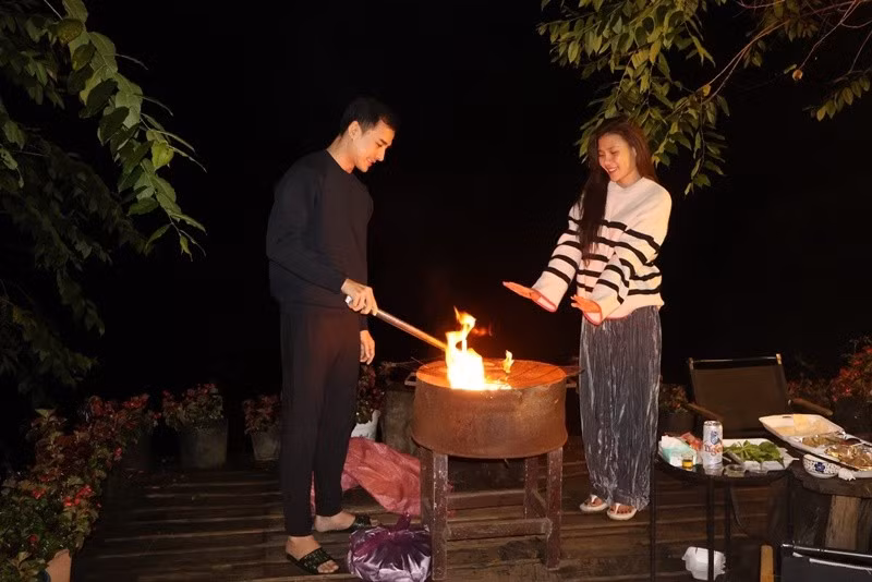 Cặp đôi đốt lửa, nướng đồ ăn. Ảnh: FB Thúy Diễm.
