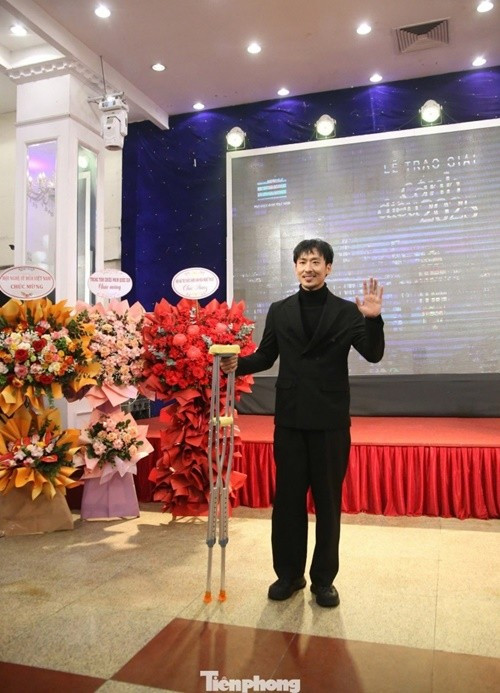 Tuấn Trần phải chống nạng khi tham gia các sự kiện trước ca phẫu thuật. Ảnh: Tiền Phong.