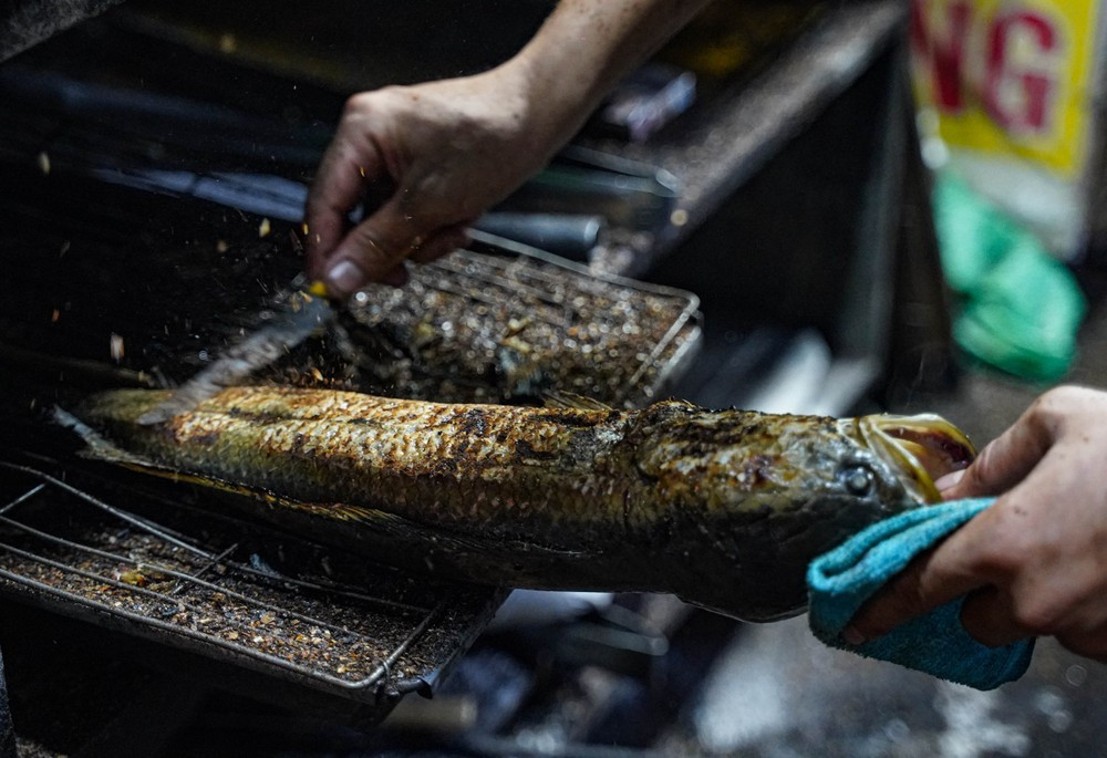 Trong quá trình nướng dưới nhiệt độ lửa than cao, người nướng phải vừa quan sát, vừa trở cá để cá không bị khét bên ngoài nhưng vẫn chín đều bên trong. Sau khi cá chín, người nướng cá sẽ dùng dao cạo đi phần da cá bị cháy xém.