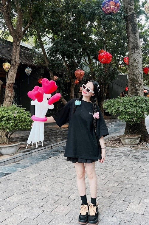 Không phải lúc nào Hòa Minzy cũng chọn váy vóc điệu đà. Trong đời thường, cô nhiều lần xuất hiện với áo phông oversize, chân váy ngắn hoặc trang phục thể thao, kết hợp giày đế dày và tất cao cổ. Kiểu phối đồ này mang lại cảm giác năng động, thoải mái và phù hợp với những buổi đi chơi ngoài trời.