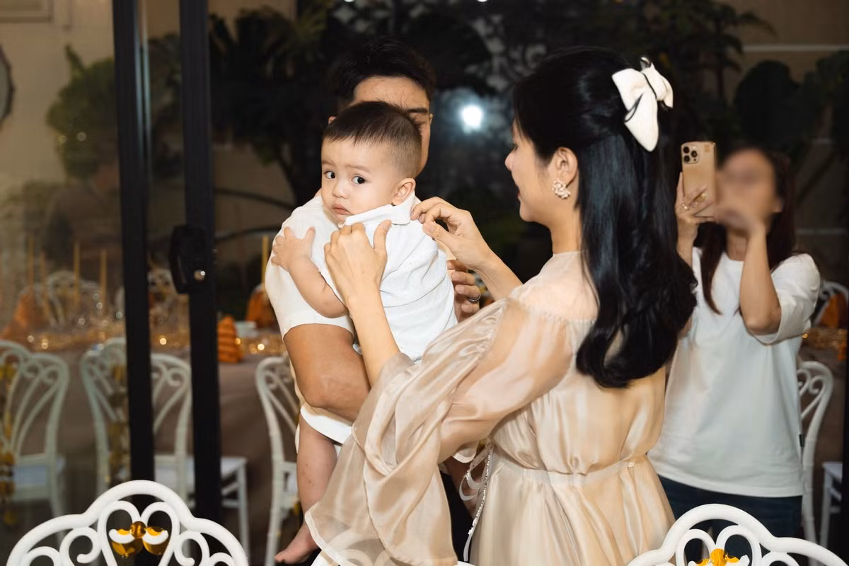 Vân Trang và chồng ân cần chăm sóc con trai út trong tiệc kỷ niệm.