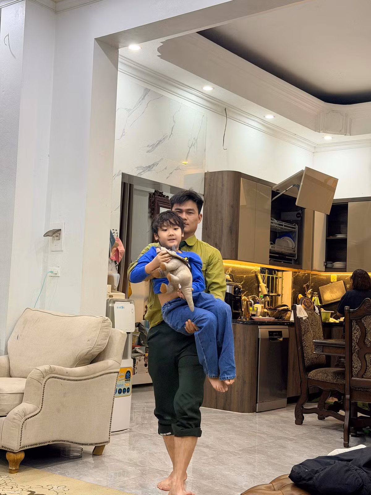 Anh nhẹ nhàng bế bồng, chơi cùng cậu bé, mang đến cảm giác gần gũi và được chở che.