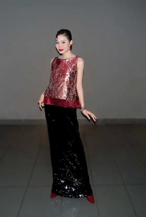 Thiết kế đỏ ánh kim và chân váy sequin trong loạt ảnh giúp Lê Lộc nổi bật ở phần trên cơ thể. Ánh sáng bắt vào chất liệu khiến tổng thể rực rỡ, người xem dễ bị thu hút bởi màu sắc và phong cách hơn là dáng vóc.