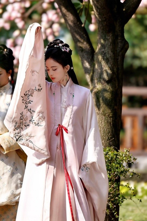 Chỉ dùng tay áo che nắng, mỹ nhân Tân Cương cũng tạo nên khoảnh khắc đẹp như tranh. Theo Tiền Phong, nhà sản xuất Vu Chính đã khéo léo chọn cho Cổ Lực Na Trát tạo hình không rườm rà nhiều chi tiết, trang phục đều có màu sắc ngọt ngào thanh nhã càng tôn lên khí chất kiêu sa của cô ở dự án phim Ngọc Minh Trà Cốt năm 2025. Ảnh: Tiền Phong.
