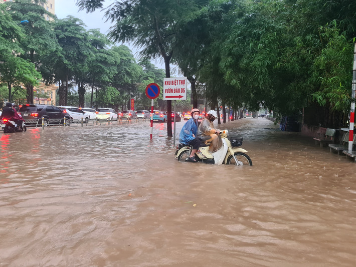 Người tham gia giao thông tìm hướng di chuyển khác nhằm thoát khỏi đoạn đường ngập úng.