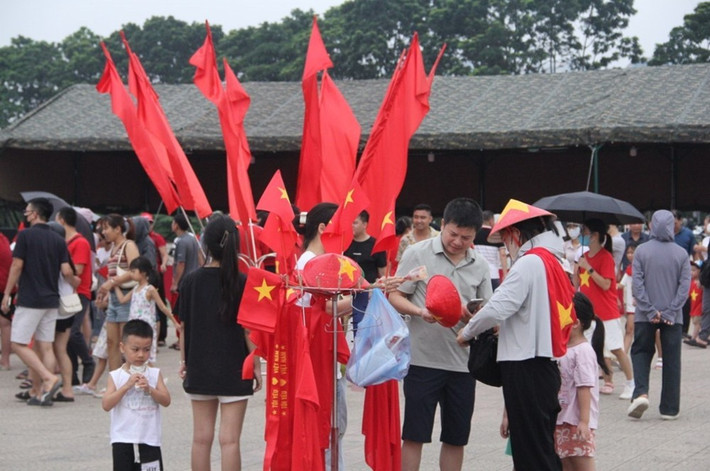 Người dân và du khách mua các phụ kiện để chụp ảnh, góp phần "nhuộm đỏ" không gian khu vực sân Mỹ Đình.