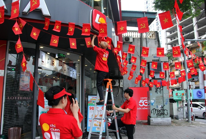 Các cửa hàng kinh doanh trên phố Kim Mã rực rỡ cờ hoa, mang lại không khí hào hùng và niềm tự hào.