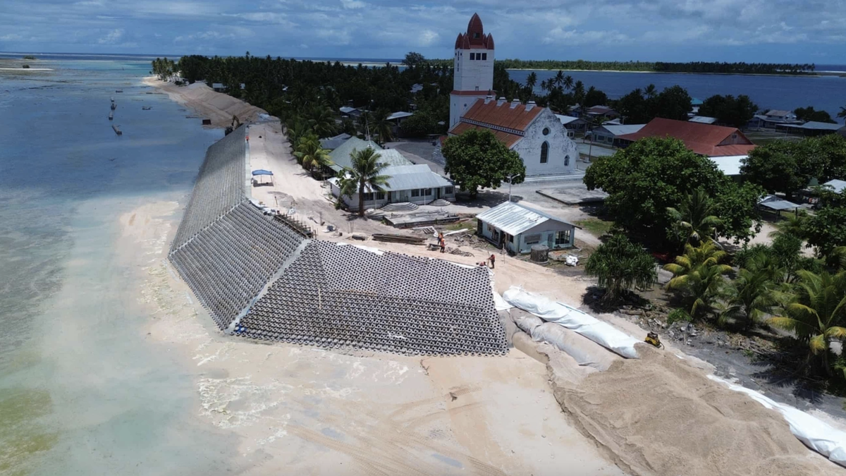 60% dân số Tuvalu sống tại thủ đô Funafuti, gồm hơn 30 đảo nhỏ, cao hơn mực nước biển chưa đầy một mét khi thủy triều dâng. Chính phủ Tuvalu cho biết mực nước biển gần quốc gia này đã tăng khoảng 5 mm mỗi năm kể từ năm 1993, cao hơn so với mức trung bình toàn cầu. Theo dự báo, 95% diện tích quốc đảo này bị ngập vào cuối thế kỷ XXI. Ngoài ra, đảo quốc này đối mặt với nhiều vấn nạn khác như hạn hán, axit hóa đại dương và quản lý rác thải. Ảnh: Dự án thích ứng bờ biển Tuvalu.