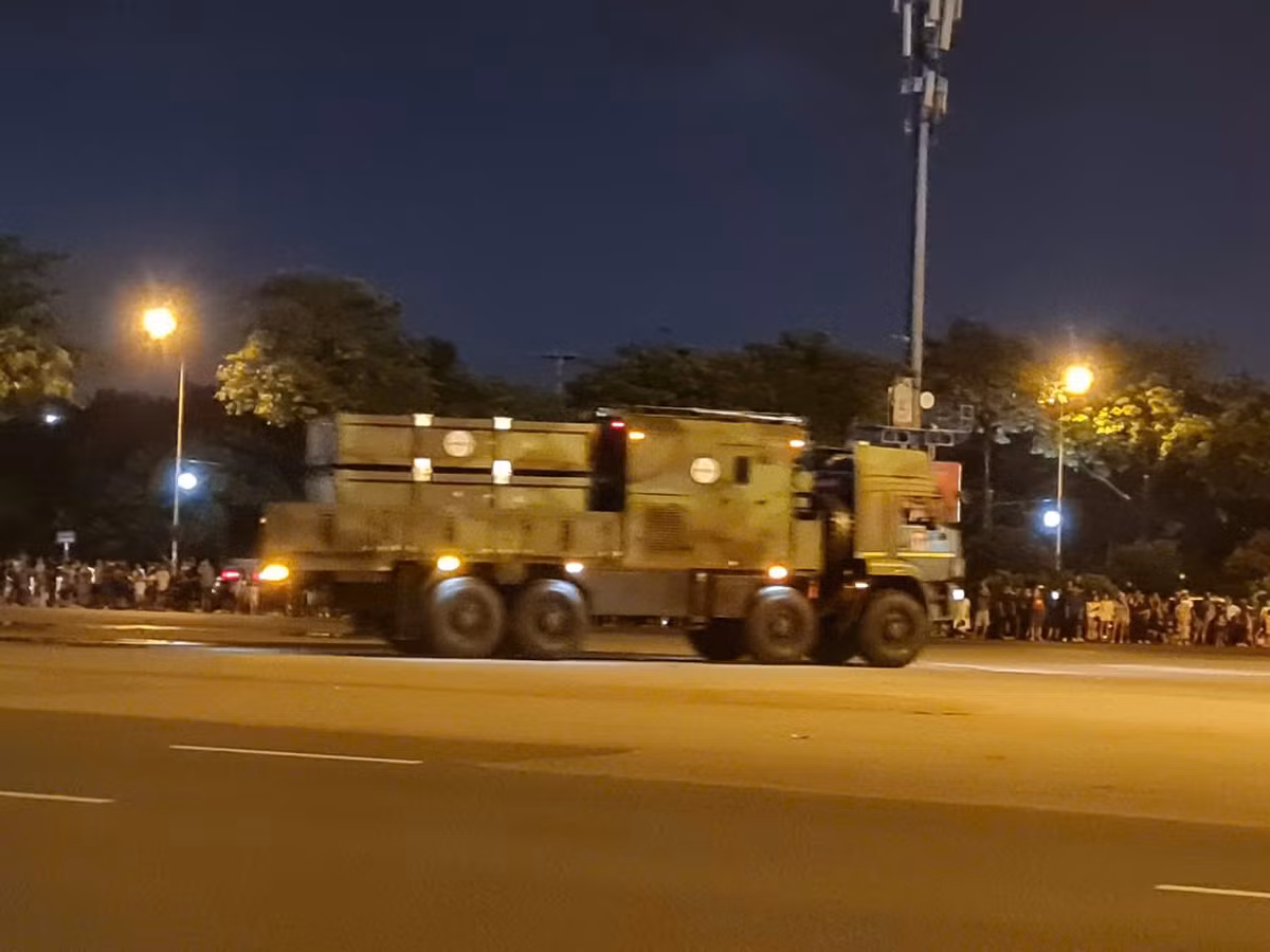 Chiếc xe tiến vào, tiếng động cơ vang vọng hòa cùng tiếng reo hò của người dân, tạo nên bầu không khí trang nghiêm nhưng đầy phấn khích.