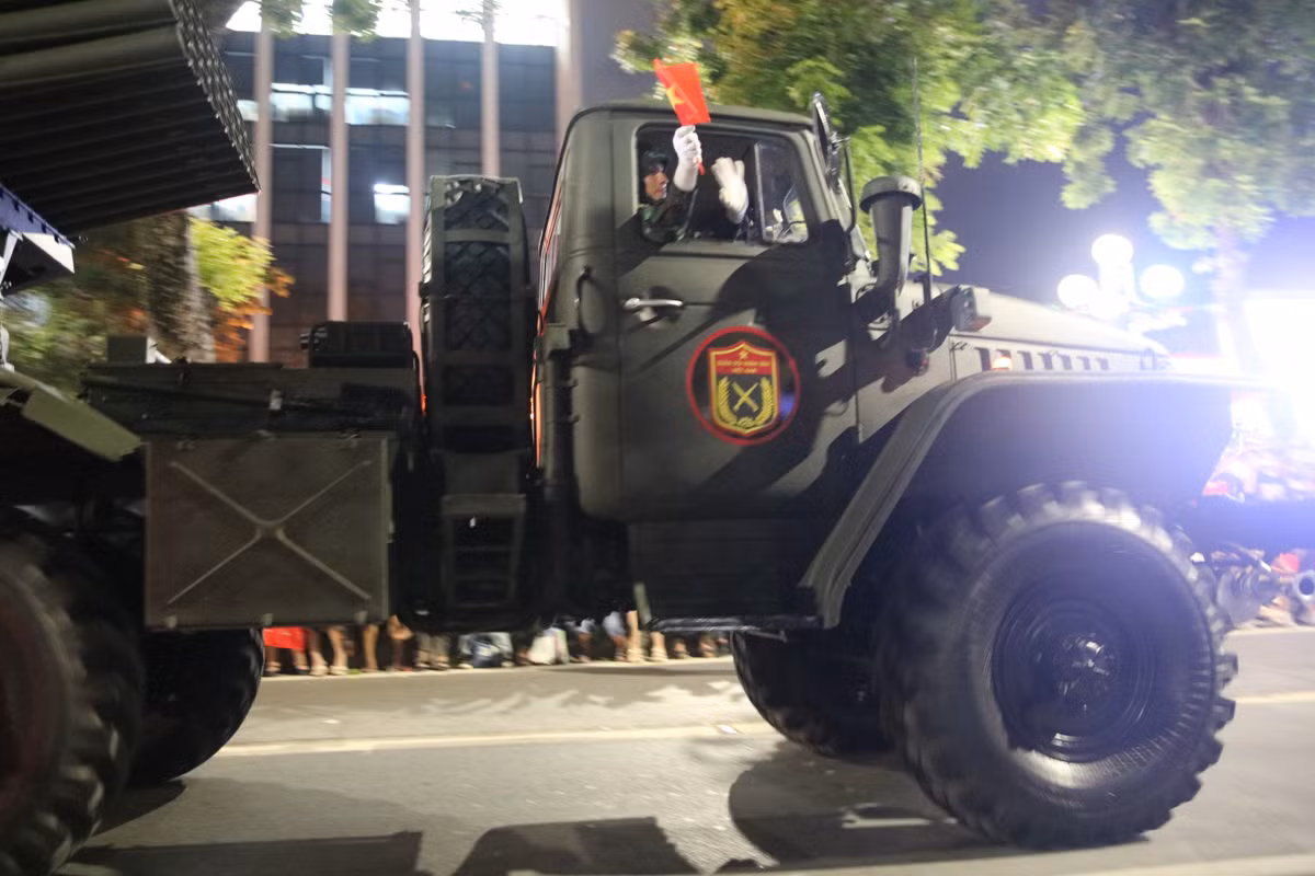 Các chiến sĩ vẫy cờ đáp lại tình cảm của người dân hai bên đường.