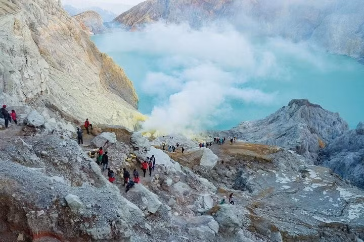 Màu xanh lục lam của hồ miệng núi lửa Kawah Ijen sáng đến mức có thể nhìn thấy từ không gian . Các khoáng chất và axit trong hồ miệng núi lửa tạo cho nước màu ngọc lam nhân tạo.