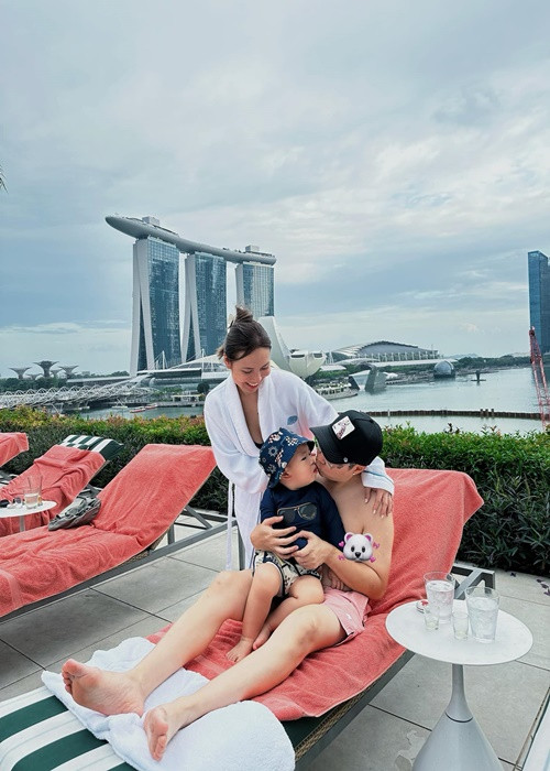 Nam ca sĩ hôn con trai bên bể bơi trong chuyến du lịch.