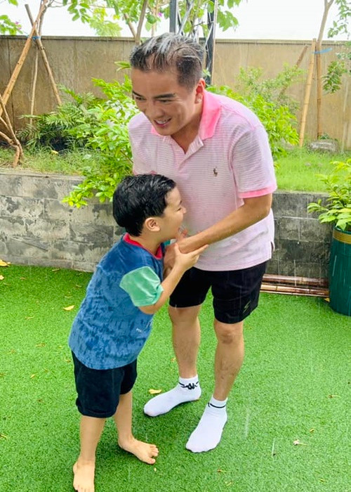 Gần đây, nam ca sĩ chia sẻ hình ảnh cùng con trai tắm mưa ở sân vườn. Ảnh: FB Đàm Vĩnh Hưng.