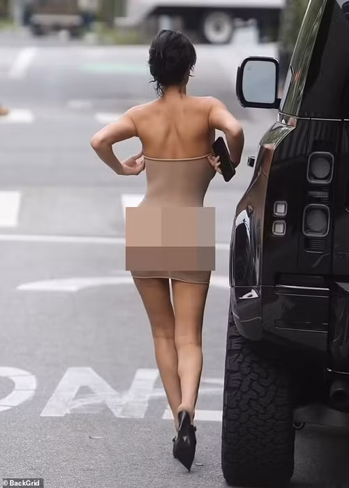 Bianca Censori còn vô tư chỉnh sửa trang phục giữa phố. Ảnh: Backgrid.