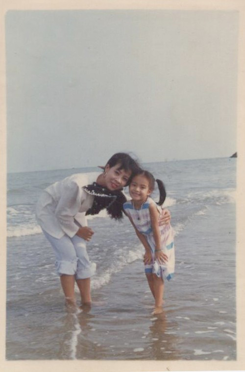 Hoàng Thùy Linh tươi tắn bên mẹ trong một chuyến đi biển ngày còn bé. Ảnh: Khám Phá.