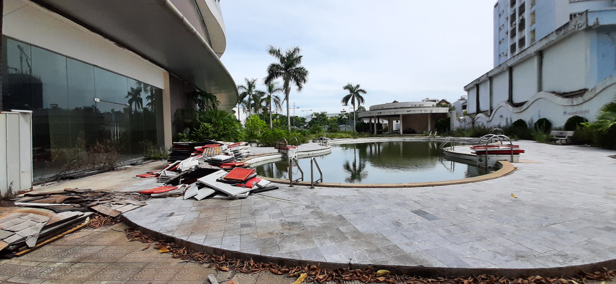 Do nhiều tháng để không nên bể bơi, sân chơi phía sau tòa nhà xập xệ, phủ đầy bụi, lá cây, cỏ mọc cao cả mét.