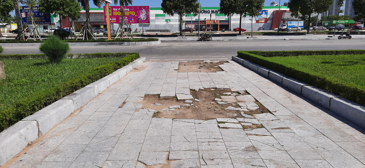 Phần làn đường dẫn vào vườn hoa cho người đi bộ qua đường xuống cấp nghiêm trọng, gạch lát bị vỡ nát, xới tung từ nhiều tháng nay, mùa nắng bị bụi mù mịt, mùa mưa thì nước đọng lại thành vũng.