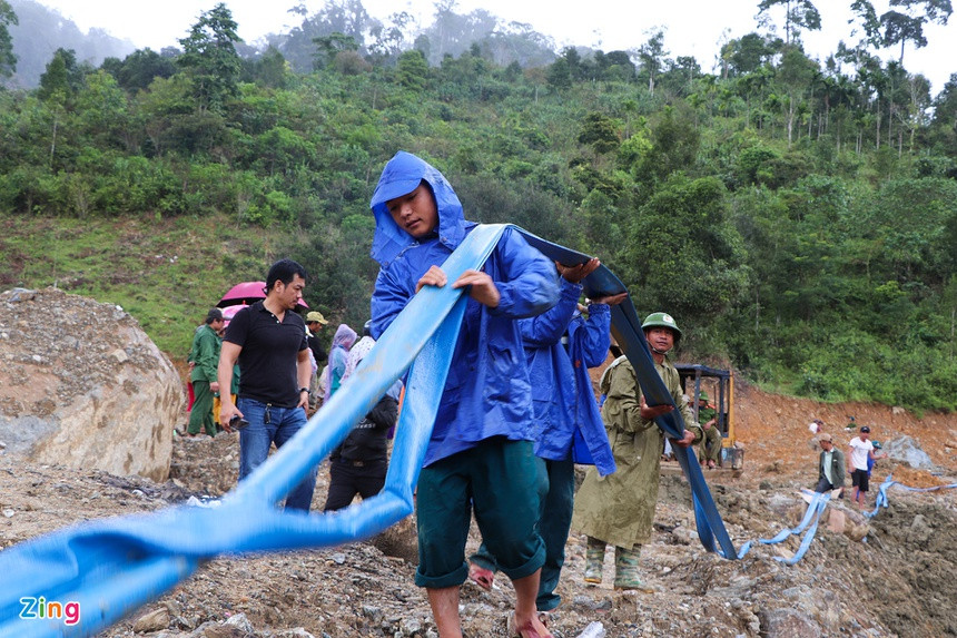 Sau khi dùng máy xúc đào xới đất, lực lượng chức năng tiếp tục dùng ống nước để phun cho bùn chảy đi.