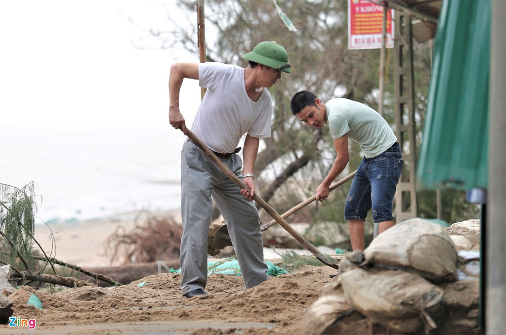 Chủ các kiốt dọc bờ biển Cửa Lò phải dọn dẹp cát, cây gãy, rác bị sóng đánh vào trước khi mở cửa trở lại. 