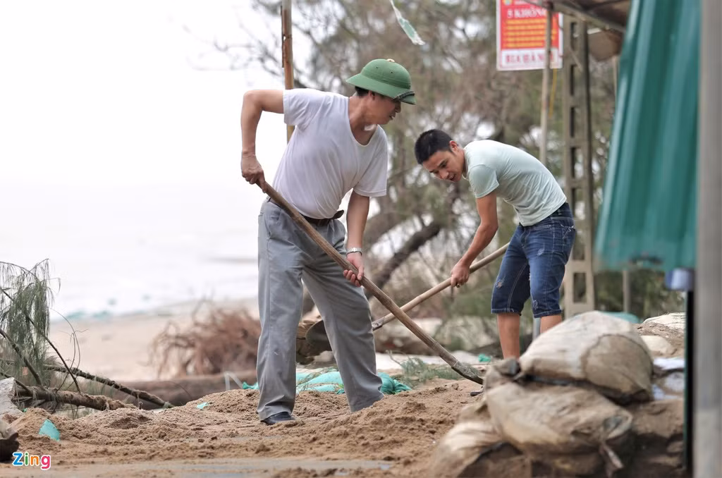 Chủ các kiốt dọc bờ biển Cửa Lò phải dọn dẹp cát, cây gãy, rác bị sóng đánh vào trước khi mở cửa trở lại. 