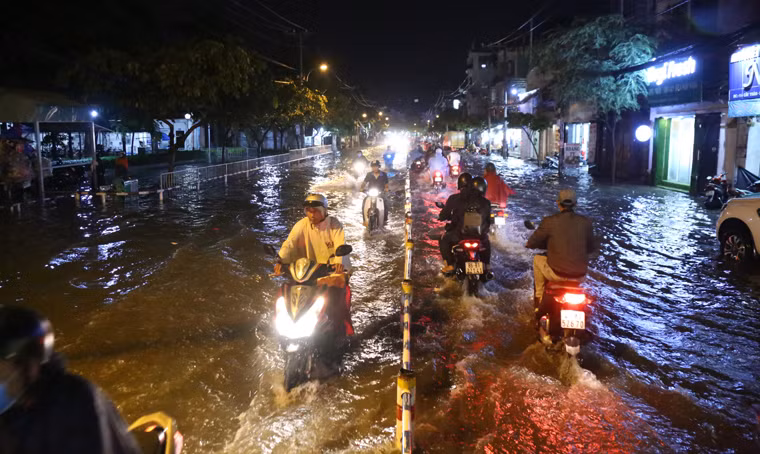 Người dân bì bõm lội qua khu vực ngập nặng trên địa bàn quận Gò Vấp, TP.HCM để tìm đường trở về nhà trong đêm.