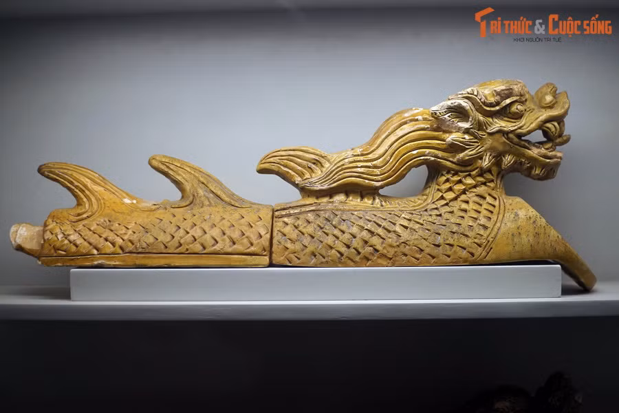 Đặc sắc nhất là loại ngói ống hình con rồng, hình tượng hóa các con rồng có thân và vây lưng nằm trải dài theo dốc mái. Ảnh: Ngói ống men vàng tạo hình rồng thời Lê sơ.