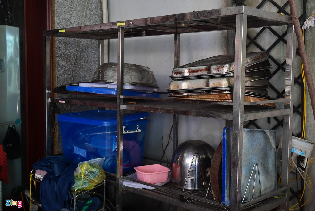 Một số máy móc, khay đựng và dụng cụ phục vụ sản xuất, vận chuyển hàng hóa nằm ngổn ngang trên kệ.