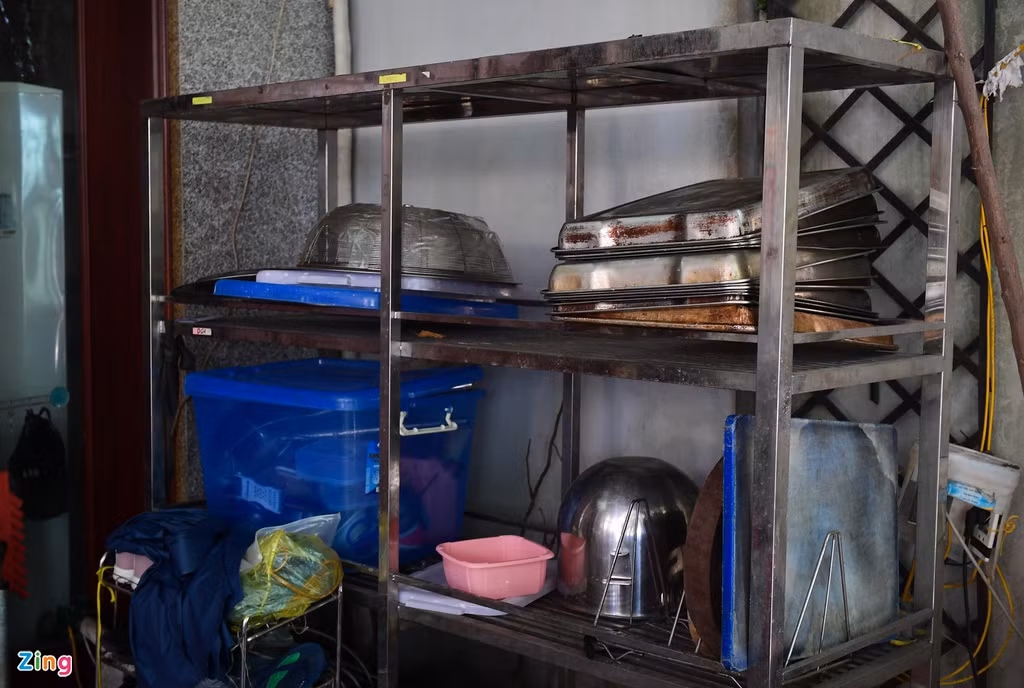 Một số máy móc, khay đựng và dụng cụ phục vụ sản xuất, vận chuyển hàng hóa nằm ngổn ngang trên kệ.