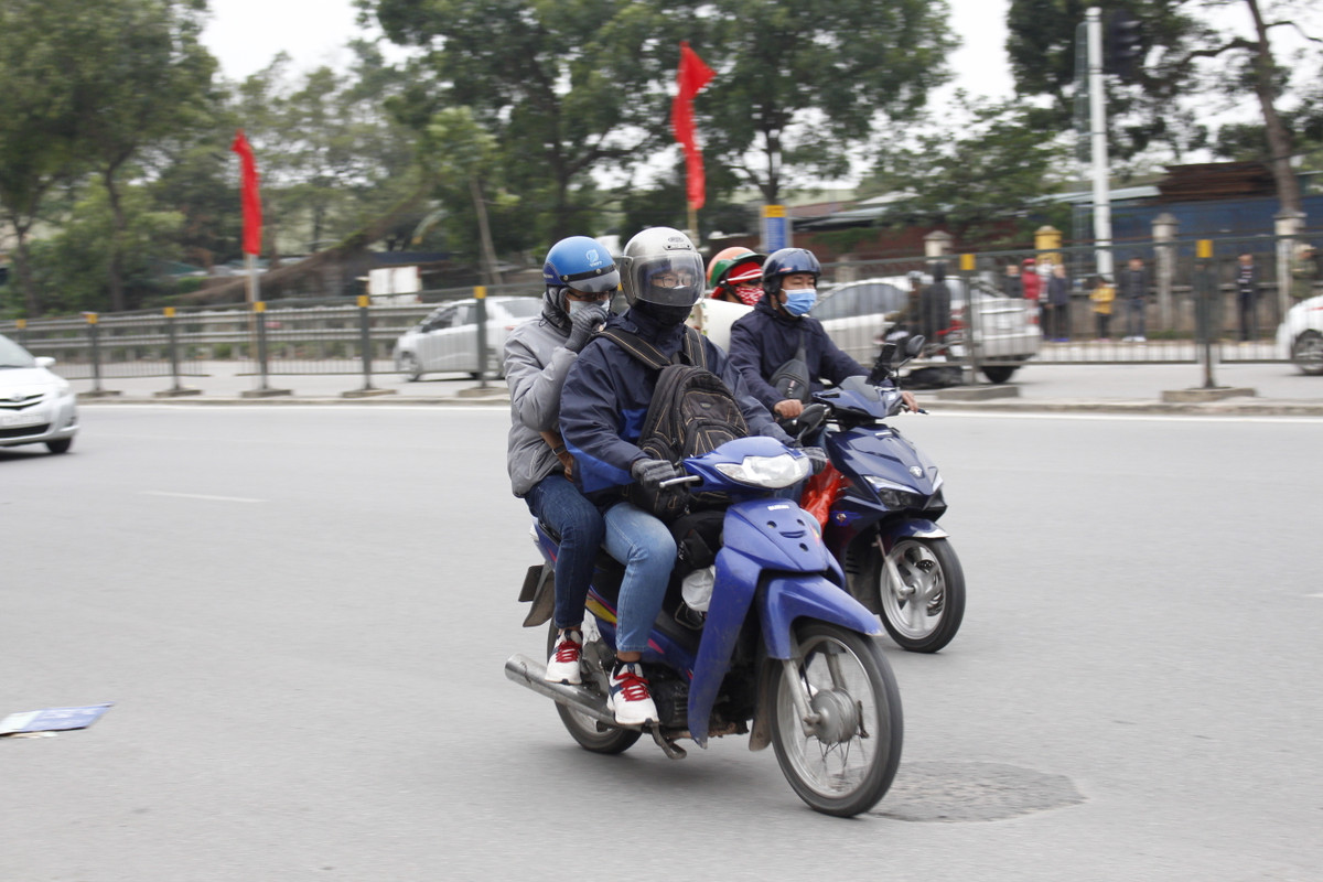 Do thời tiết lạnh khiến người dân phải trang bị quần áo thật ấm, nhiều người mặc cả áo mưa.