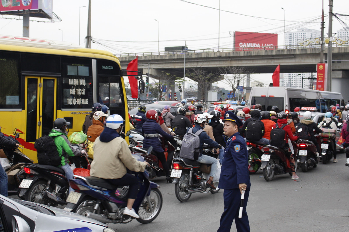 Lực lượng chức năng phân luồng giao thông để đảm bảo trong và ngoài bến xe không xảy ra tình trạng ùn ứ và mất an ninh trật tự. Người dân co ro trở lại Hà Nội sau kỳ nghỉ lễ. (Nguồn: VTC14)