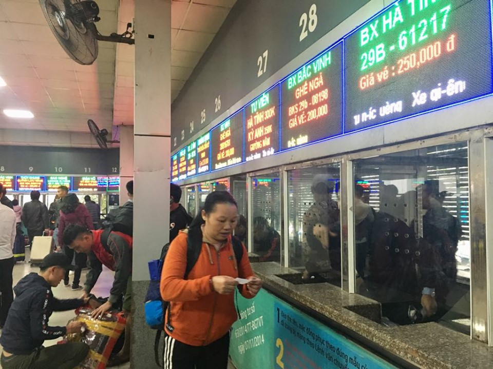 Do lượng khách tăng cao hành khách phải sếp hàng mua vé, hành khách ngồi chật kín phòng chờ.