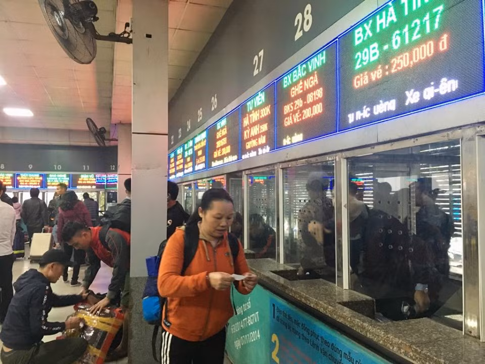 Do lượng khách tăng cao hành khách phải sếp hàng mua vé, hành khách ngồi chật kín phòng chờ.